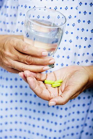 simsearch:625-02932810,k - Mid section view of a woman holding a glass of water and pills Fotografie stock - Premium Royalty-Free, Codice: 625-01249638