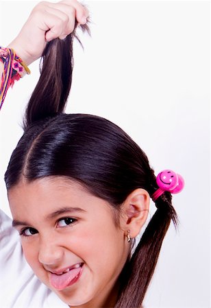 Portrait of a girl pulling her pigtails Stock Photo - Premium Royalty-Free, Code: 625-01249777