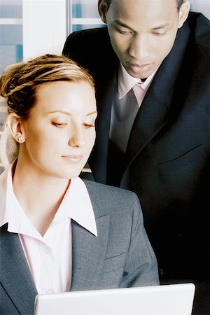 simsearch:630-03481503,k - Close-up of a businessman and a businesswoman looking at a laptop Fotografie stock - Premium Royalty-Free, Codice: 625-01249788