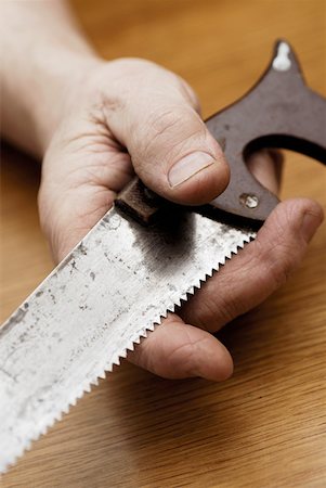 Close-up of a person's hand holding a saw Stock Photo - Premium Royalty-Free, Code: 625-01249998