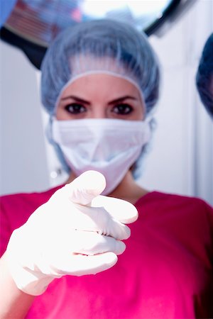 female doctor glove women only - Portrait of a female surgeon pointing forward Stock Photo - Premium Royalty-Free, Code: 625-01250026