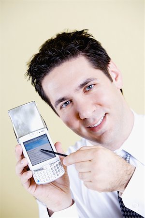 simsearch:625-02266709,k - Portrait of a businessman showing a mobile phone Foto de stock - Sin royalties Premium, Código: 625-01250034