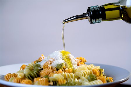 fusilli - Olive oil being poured on a plate of pasta Stock Photo - Premium Royalty-Free, Code: 625-01250059