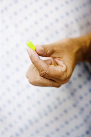 simsearch:625-02932810,k - Close-up of a woman's hand holding a pill Fotografie stock - Premium Royalty-Free, Codice: 625-01250202