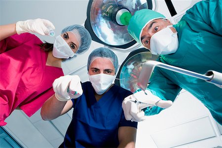 simsearch:625-01249642,k - Low angle view of two male surgeons and a female surgeon holding surgical equipments Stock Photo - Premium Royalty-Free, Code: 625-01250231