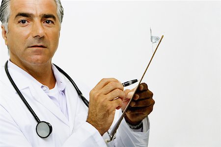 reports white background - Portrait of a male doctor writing on a clipboard Stock Photo - Premium Royalty-Free, Code: 625-01250303