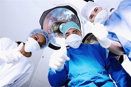 Male surgeon and two female surgeons making Thumbs Up sign Stock Photo - Premium Royalty-Free, Code: 625-01250314