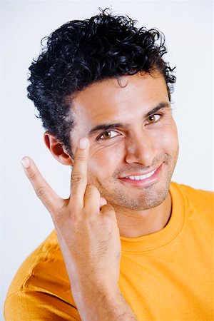 peace symbol with hands - Portrait of a young man making a peace sign Stock Photo - Premium Royalty-Free, Code: 625-01250463