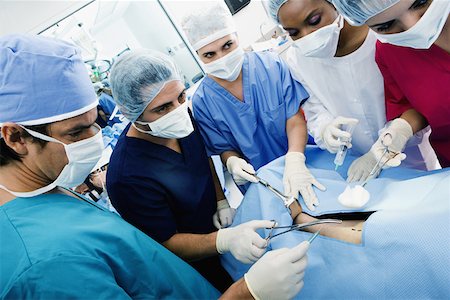 Three female surgeons and two male surgeons operating a patient Stock Photo - Premium Royalty-Free, Code: 625-01250494