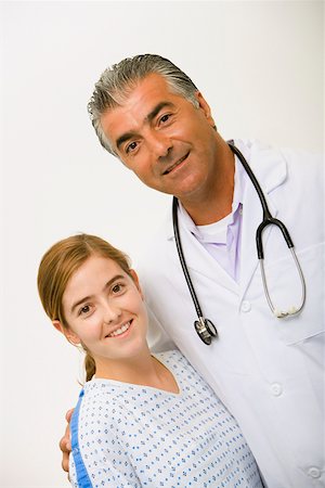 doctor patient standing white background - Portrait of a male doctor and a young woman smiling Stock Photo - Premium Royalty-Free, Code: 625-01250580