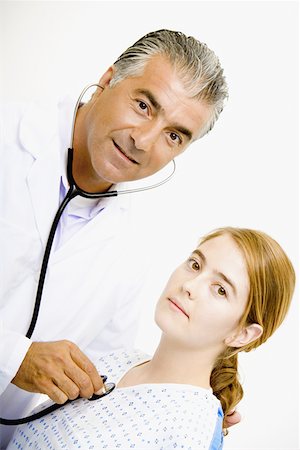 simsearch:625-01252198,k - Portrait of a male doctor examining a young woman with a stethoscope Foto de stock - Royalty Free Premium, Número: 625-01250952