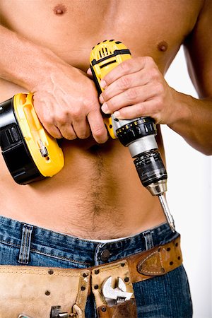 Mid section view of a man holding a drill machine Stock Photo - Premium Royalty-Free, Code: 625-01251036