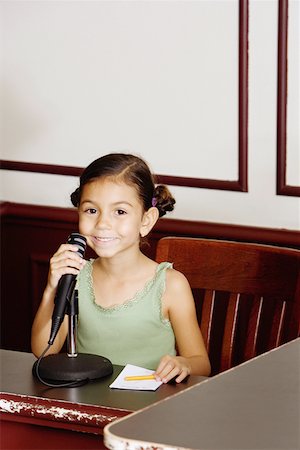 Portrait d'une jeune fille tenant un micro et souriant Photographie de stock - Premium Libres de Droits, Code: 625-01251182