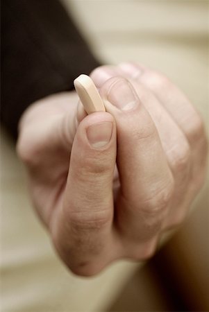 simsearch:625-02932810,k - Close-up of a person's hand holding a pill Fotografie stock - Premium Royalty-Free, Codice: 625-01251344