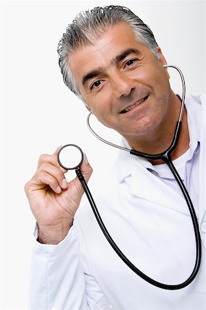 simsearch:625-01097164,k - Portrait d'un médecin de sexe masculin tenant un stéthoscope et souriant Photographie de stock - Premium Libres de Droits, Code: 625-01251364