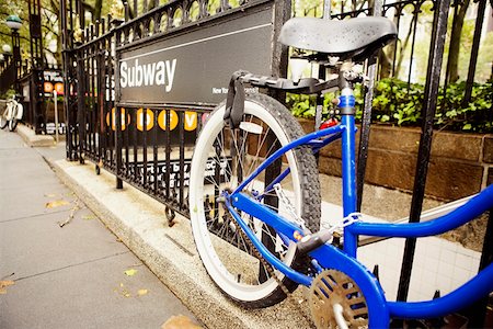 simbolo della metropolitana - Close-up of a bicycle locked to a subway station railing Fotografie stock - Premium Royalty-Free, Codice: 625-01251360