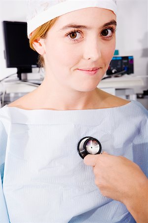 simsearch:625-01252179,k - Close-up of a doctor's hand holding a stethoscope and examining a female patient Stock Photo - Premium Royalty-Free, Code: 625-01251414