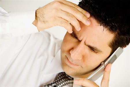 sad man talking phone - Close-up of a businessman talking on a mobile phone Stock Photo - Premium Royalty-Free, Code: 625-01251420