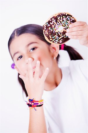 Portrait d'une jeune fille tenant un beignet et lécher son doigt Photographie de stock - Premium Libres de Droits, Code: 625-01251486