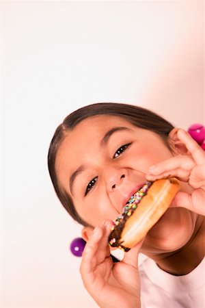 simsearch:625-01251733,k - Portrait d'une jeune fille mangeant un beignet Photographie de stock - Premium Libres de Droits, Code: 625-01251582