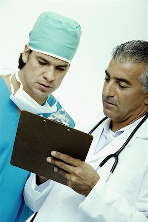 simsearch:625-01252198,k - Close-up of a male doctor discussing a report with a surgeon Foto de stock - Royalty Free Premium, Número: 625-01251930