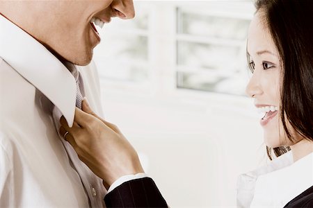 Side profile of a businesswoman adjusting a businessman's tie Stock Photo - Premium Royalty-Free, Code: 625-01251967