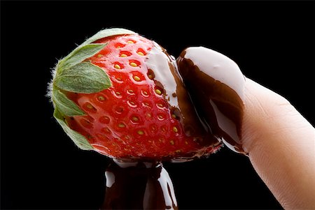 Gros plan de la main d'une personne détenant une fraise recouverte de chocolat Photographie de stock - Premium Libres de Droits, Code: 625-01251984