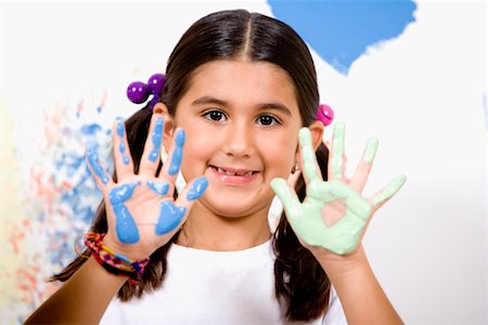 Portrait of a girl showing paint on her palms with her father smiling Stock Photo - Premium Royalty-Free, Code: 625-01252142