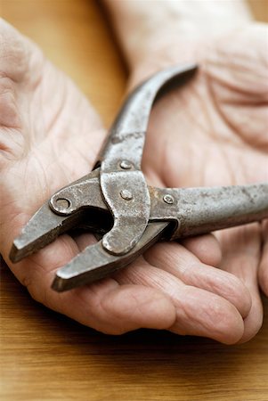 servicio público (agua, electricidad) - Close-up of a pair of pliers on a person's palm Foto de stock - Sin royalties Premium, Código: 625-01252163