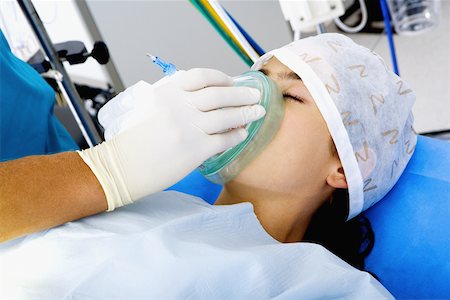 simsearch:625-01252198,k - Surgeon's hand putting an oxygen mask on a female patient Foto de stock - Royalty Free Premium, Número: 625-01252182