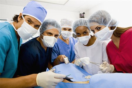 Portrait of three female surgeons and two male surgeons operating a patient Stock Photo - Premium Royalty-Free, Code: 625-01252229