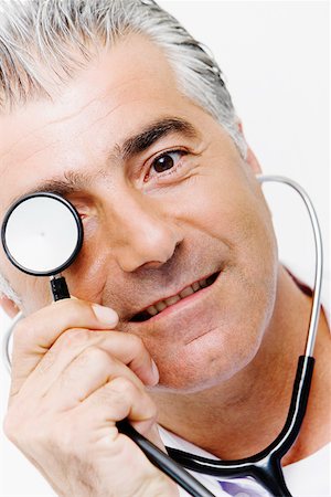 simsearch:625-01252198,k - Portrait of a male doctor holding a stethoscope in front of his eyes Foto de stock - Royalty Free Premium, Número: 625-01252255