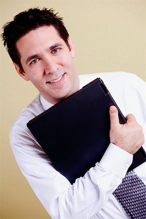 simsearch:625-01096675,k - Portrait of a businessman holding a laptop and smiling Stock Photo - Premium Royalty-Free, Code: 625-01252251