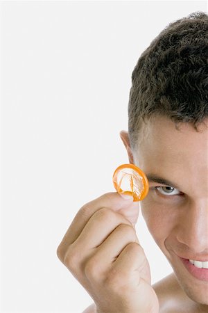 simsearch:625-00851085,k - Portrait of a young man showing a condom Foto de stock - Royalty Free Premium, Número: 625-01252518