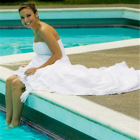 swimming formal dress - Portrait of a bride sitting a the poolside and smiling Stock Photo - Premium Royalty-Free, Code: 625-01264022