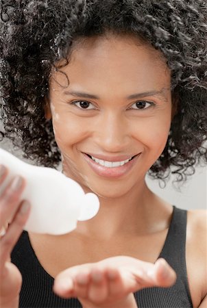 simsearch:625-01097322,k - Portrait of a young woman squeezing moisturizer on her hand Stock Photo - Premium Royalty-Free, Code: 625-01264081