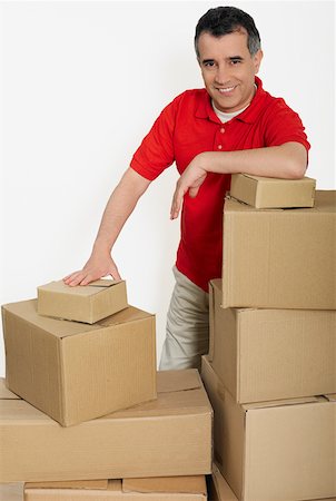 Portrait of a mid adult man standing with cardboard boxes Stock Photo - Premium Royalty-Free, Code: 625-01264195
