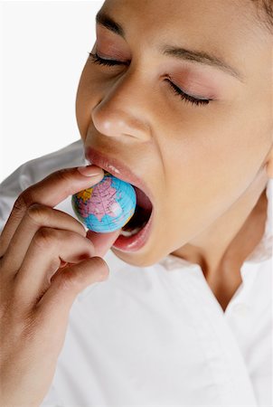 Close-up of a businesswoman holding a globe in her mouth Stock Photo - Premium Royalty-Free, Code: 625-01264192