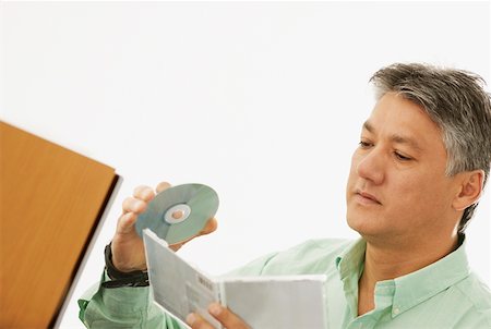 simsearch:625-02267785,k - Close-up of a senior man holding a CD and a CD Case Foto de stock - Royalty Free Premium, Número: 625-01264446