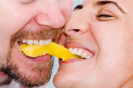 fruit eyes not children - Close-up of a mid adult couple biting into a slice of fruit together Stock Photo - Premium Royalty-Free, Code: 625-01264506