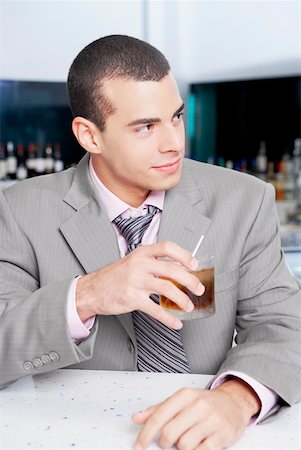 Close-up of a businessman holding a glass of cocktail in a bar Stock Photo - Premium Royalty-Free, Code: 625-01264542