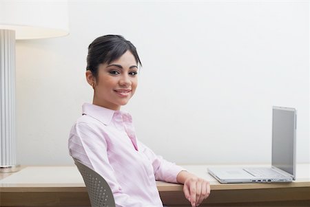 student latino business casual - Portrait of a businesswoman sitting in front of a laptop Stock Photo - Premium Royalty-Free, Code: 625-01264666