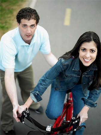 simsearch:625-01095436,k - High angle view of a mid adult man helping a mid adult woman ride a bicycle Stock Photo - Premium Royalty-Free, Code: 625-01264926