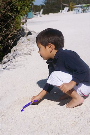 Side profile of a boy playing in sand Stock Photo - Premium Royalty-Free, Code: 625-01265064