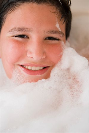 Portrait d'un garçon souriant dans un bain moussant Photographie de stock - Premium Libres de Droits, Code: 625-01265063
