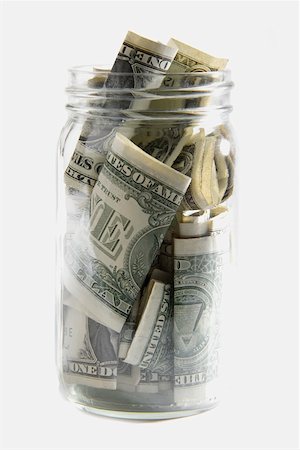 Dollar bills squashed into a jar Stock Photo - Premium Royalty-Free, Code: 625-01265073
