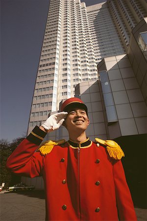 Bellhop saluting in front of a hotel, Tokyo Prefecture, Japan Stock Photo - Premium Royalty-Free, Code: 625-01265118