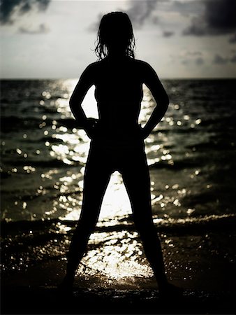Silhouette of a young woman standing on the beach Stock Photo - Premium Royalty-Free, Code: 625-01265135