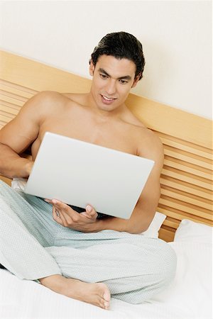 Young man using a laptop Stock Photo - Premium Royalty-Free, Code: 625-01260760