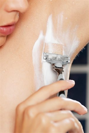 Close-up of a young woman shaving her armpit Stock Photo - Premium Royalty-Free, Code: 625-01260912